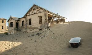 Exterior de una casa abandonada entre dunas en Kolmanskop, ciudad fantasma del sur de Namibia