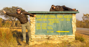 Equipo de Viajes África en el cartel de Kafue National Park, Zambia, expertos en safaris de lujo en parques nacionales.