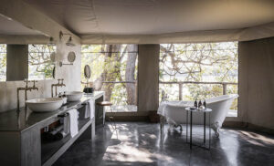 Baño con bañera y vistas al río en Sungani Lodge, South Luangwa, Zambia, alojamiento de lujo para safaris exclusivos.