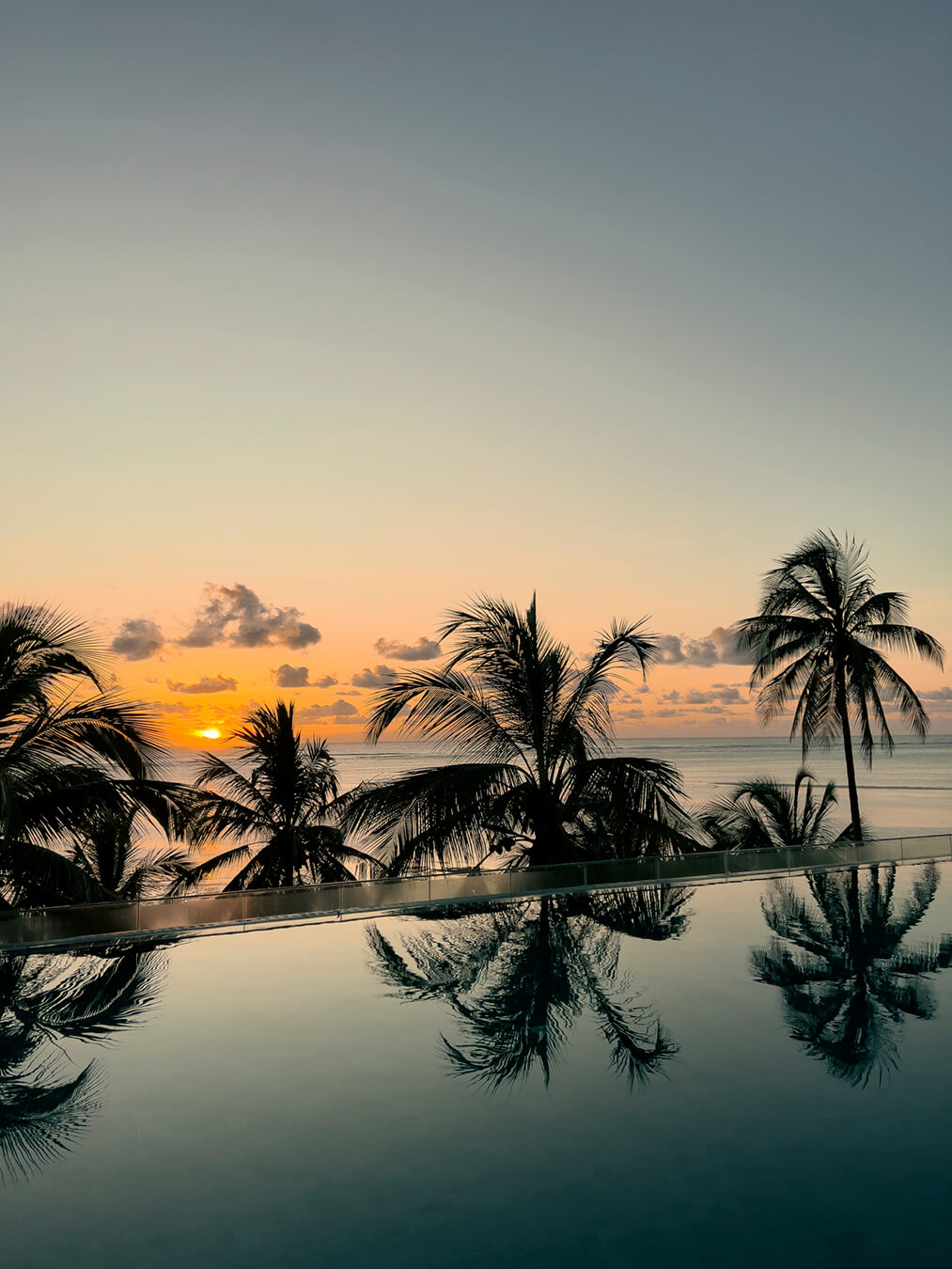 Piscina infinita frente al océano Índico al atardecer en Zanzíbar para una luna de miel en África.