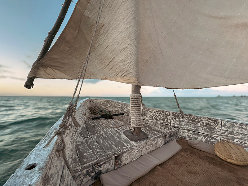 Dhow tradicional navegando al atardecer frente a la costa de Mozambique