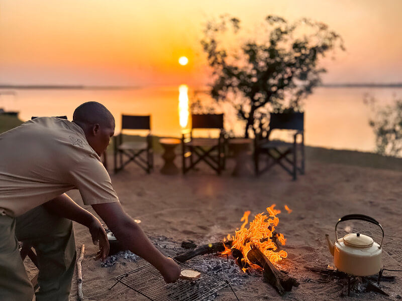 Desayuno preparado al amanecer frente al río Zambeze durante una experiencia en Zambia